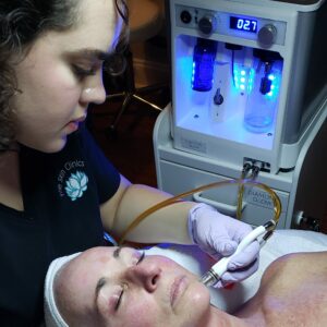 one of The Skin Clinics' estheticians giving a client a diamond glow facial treatment