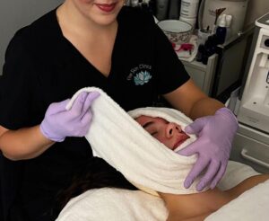 an esthetician at The Skin Clinics giving a client a custom facial