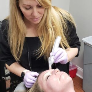 an esthetician from The Skin Clinics performing microneedling on a client