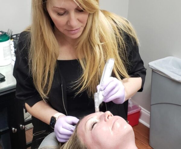 an esthetician from The Skin Clinics performing microneedling on a client