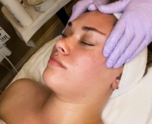 an esthetician at The Skin Clinics giving a client a relaxation facial