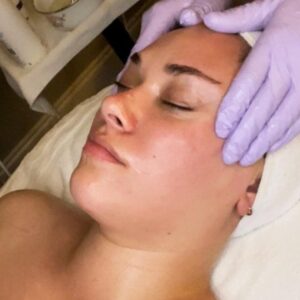 an esthetician at The Skin Clinics giving a client a relaxation facial